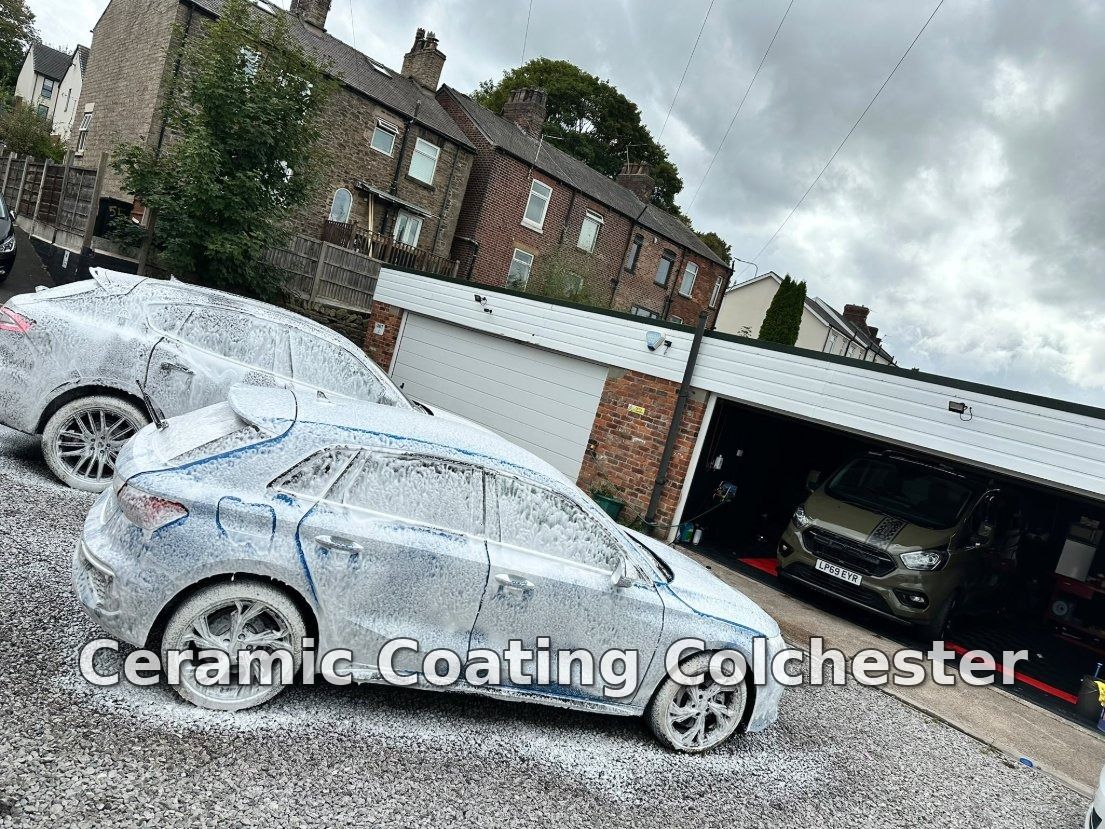 Cars covered in snow foam during the pre-wash stage outside a detailing workshop